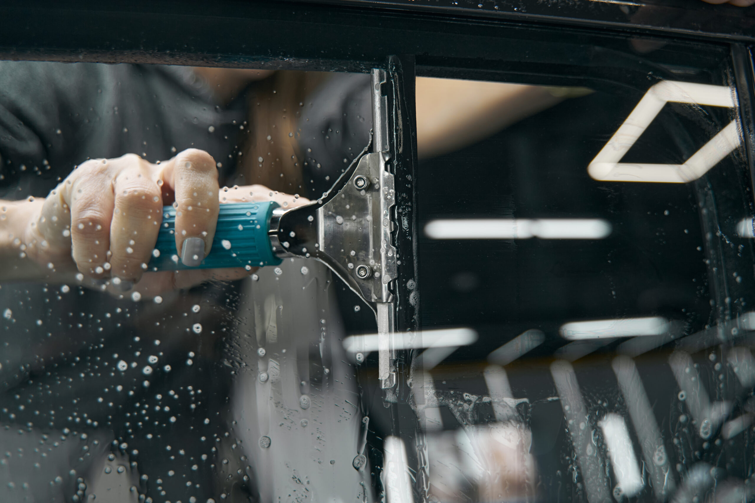 Detailer hand-cleaning a car window